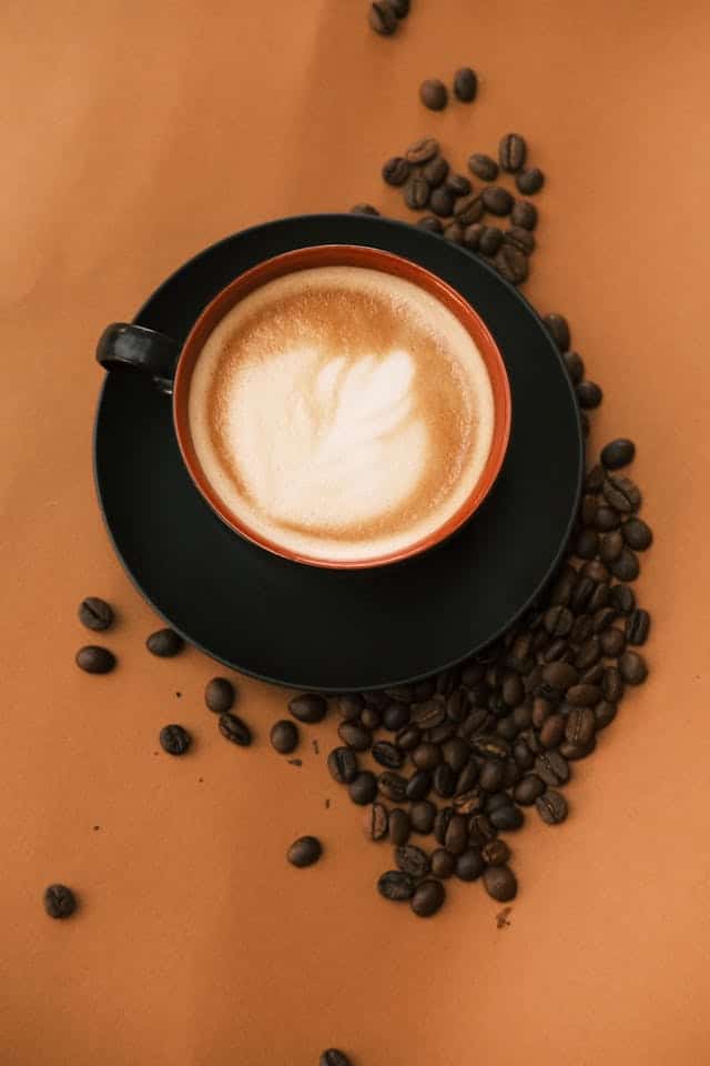 Tasse de café avec fèves de café autour